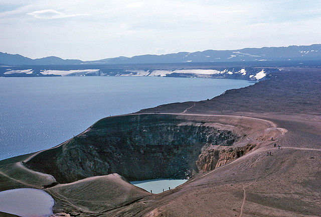 A crater lake, a volcanic crater, and rolling barren landscape.